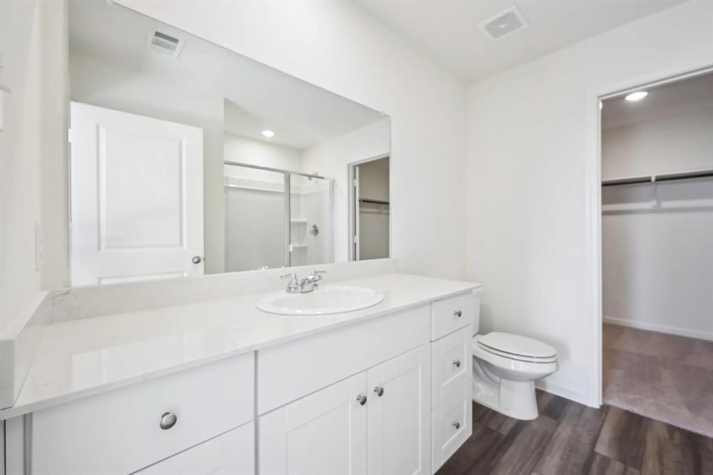 2012 Prairie Lane Melissa, TX 75454 - Photo 19 of 22 a bathroom with a sink a toilet and a large mirror