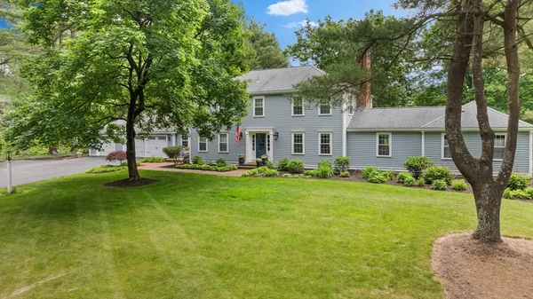 a front view of a house with a yard and tree