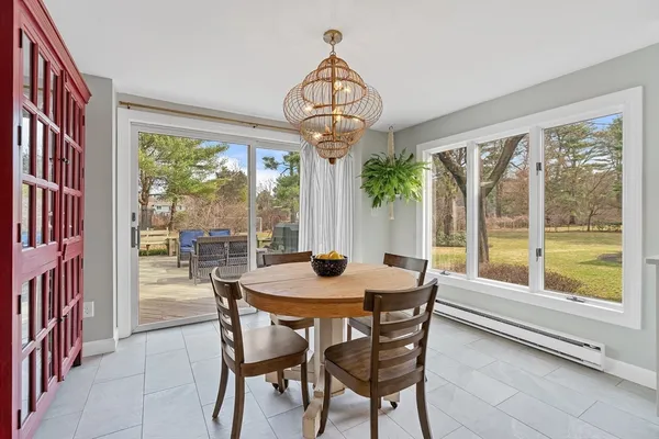 a dining room with furniture large windows and a chandelier