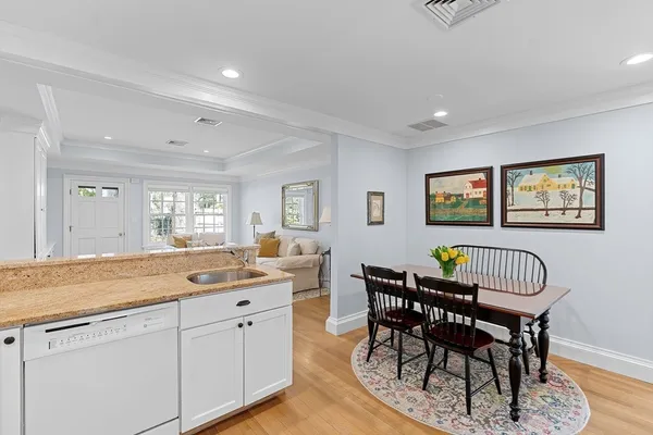 a dining hall with stainless steel appliances granite countertop a dining table and chairs