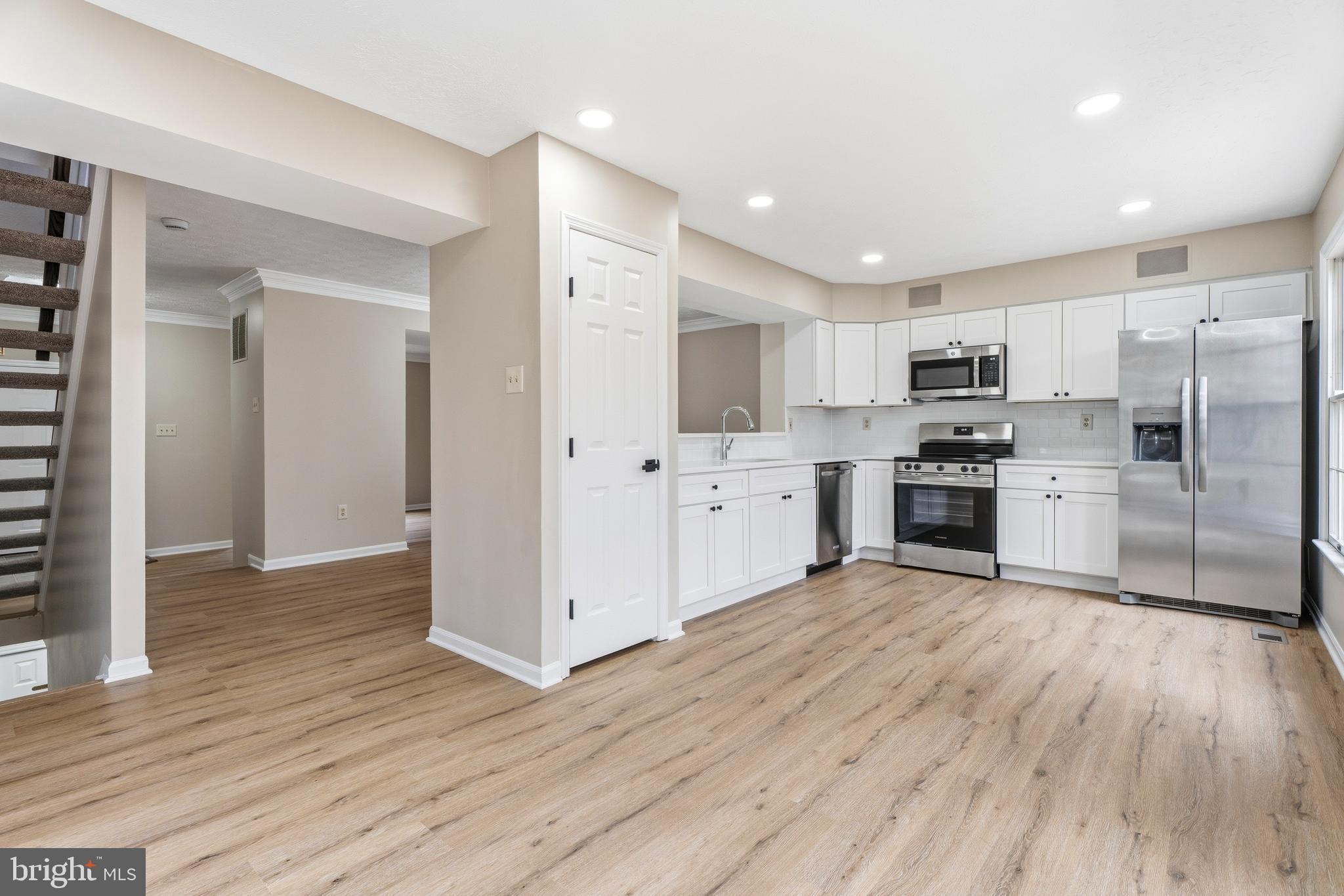 2717 Quarry Heights Way Baltimore, MD 21209 - Photo 14 of 58 a kitchen with white cabinets and stainless steel appliances