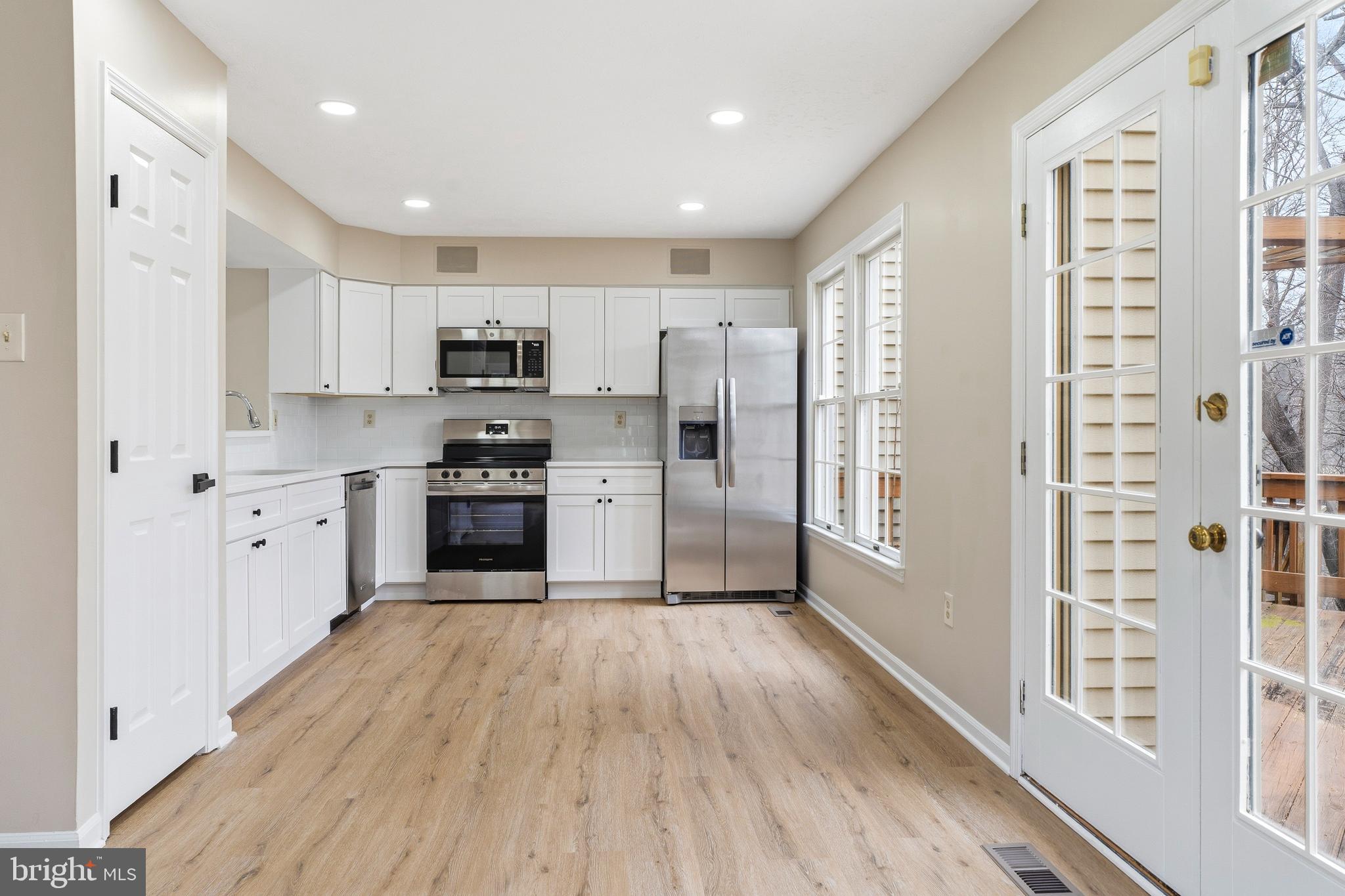 2717 Quarry Heights Way Baltimore, MD 21209 - Photo 15 of 58 a kitchen with granite countertop a refrigerator oven a sink and dishwasher with wooden floor
