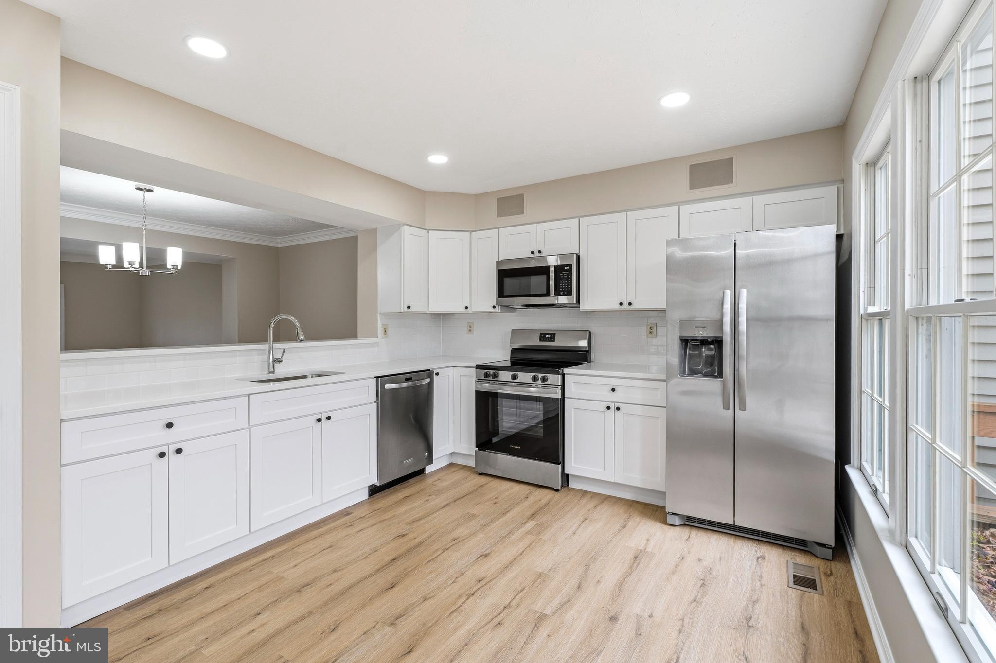 2717 Quarry Heights Way Baltimore, MD 21209 - Photo 16 of 58 a kitchen with white cabinets stainless steel appliances and a window
