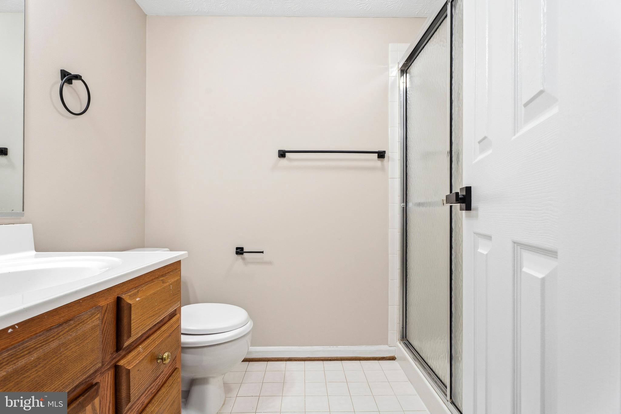 2717 Quarry Heights Way Baltimore, MD 21209 - Photo 47 of 58 a bathroom with a granite countertop toilet a sink and a shower