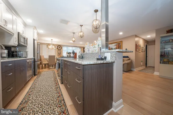 a kitchen with stainless steel appliances granite countertop a sink stove and cabinets