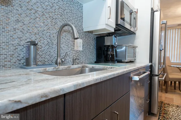 a kitchen with stainless steel appliances granite countertop a sink and a wooden floors