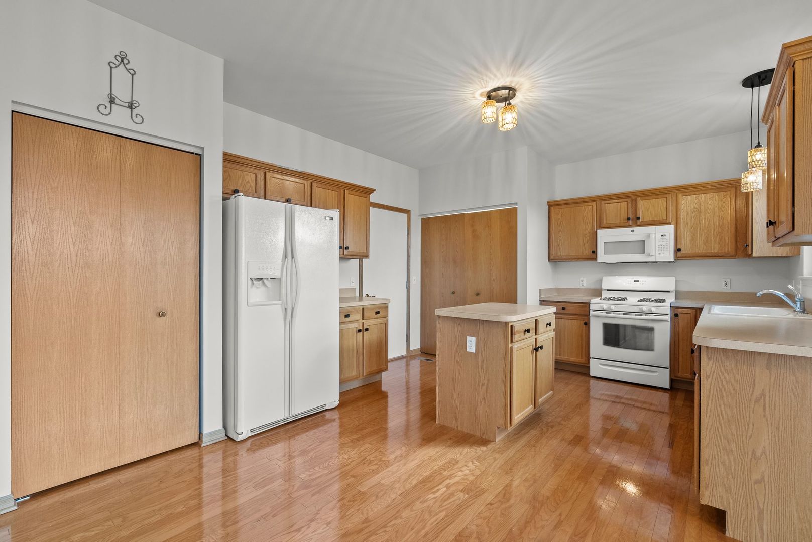 1534 Cadillac Circle Romeoville, IL 60446 - Photo 5 of 25 a kitchen with a refrigerator a stove top oven a sink and dishwasher with wooden floor