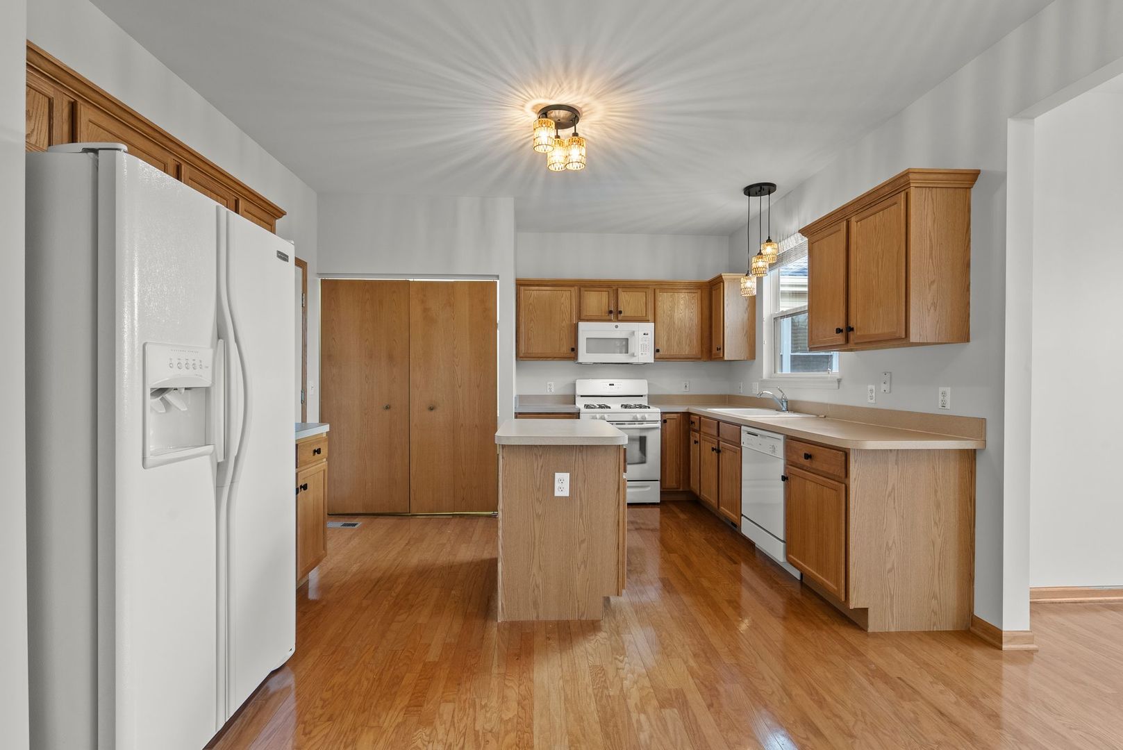 1534 Cadillac Circle Romeoville, IL 60446 - Photo 7 of 25 a kitchen with stainless steel appliances granite countertop a refrigerator a sink dishwasher a stove with wooden floor and cabinets