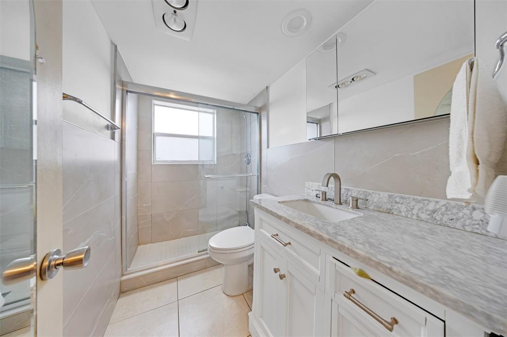 2681 South Course Drive, Unit 301 Pompano Beach, FL 33069 - Photo 13 of 27 a bathroom with a granite countertop sink toilet and shower