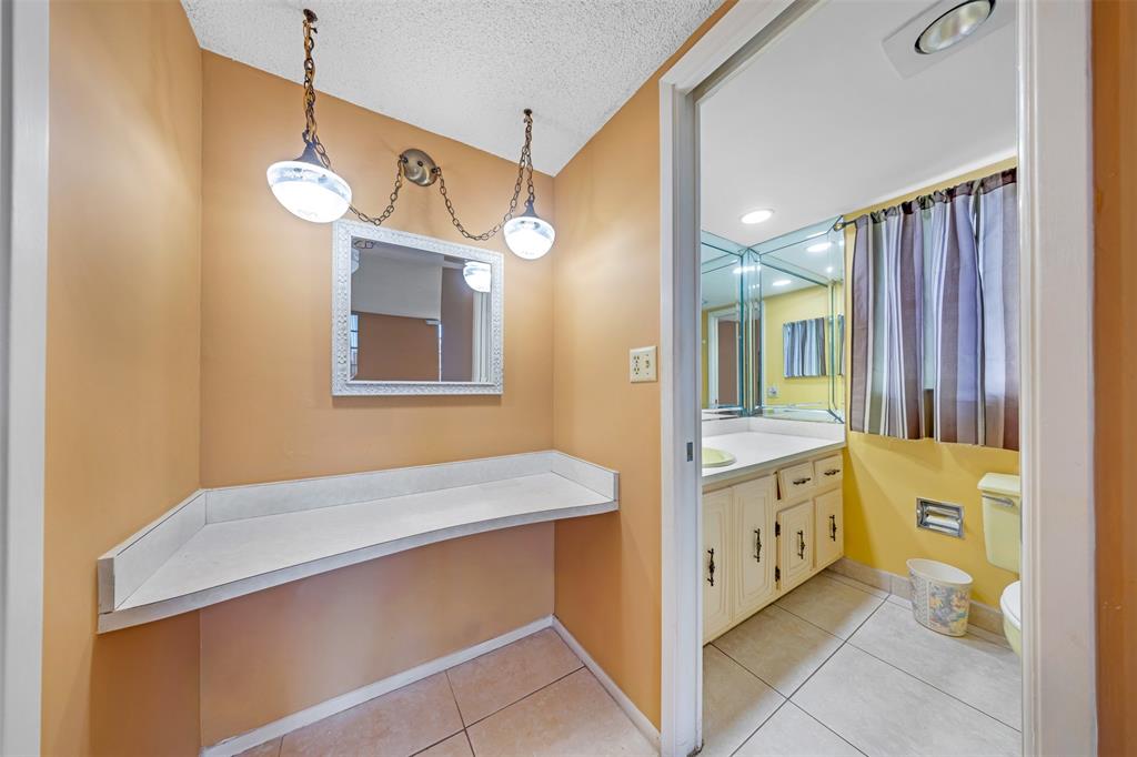 2681 South Course Drive, Unit 301 Pompano Beach, FL 33069 - Photo 17 of 27 a bathroom with a sink a vanity and a large mirror