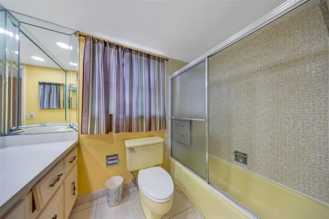 a bathroom with a sink a toilet a mirror and shower