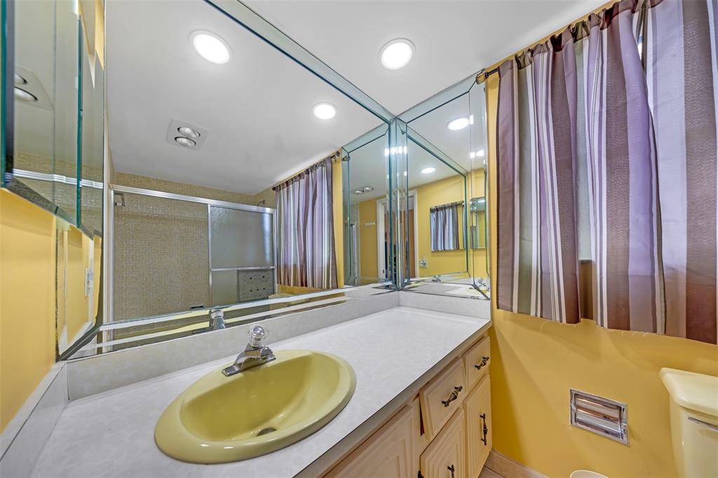 2681 South Course Drive, Unit 301 Pompano Beach, FL 33069 - Photo 19 of 27 a bathroom with a granite countertop sink and a mirror