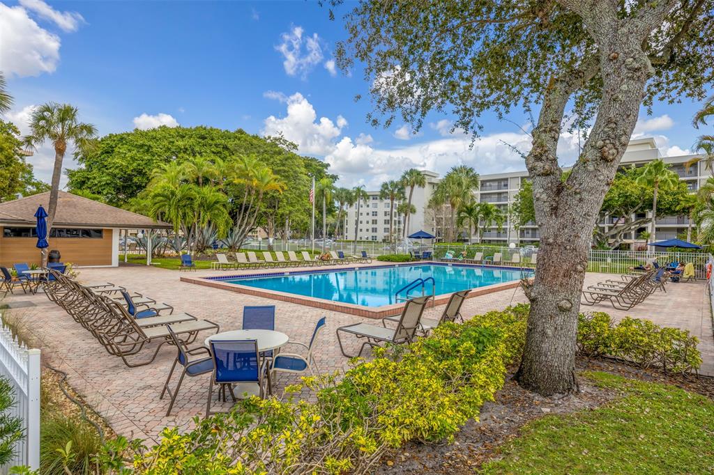 2681 South Course Drive, Unit 301 Pompano Beach, FL 33069 - Photo 26 of 27 a swimming pool with outdoor seating and yard