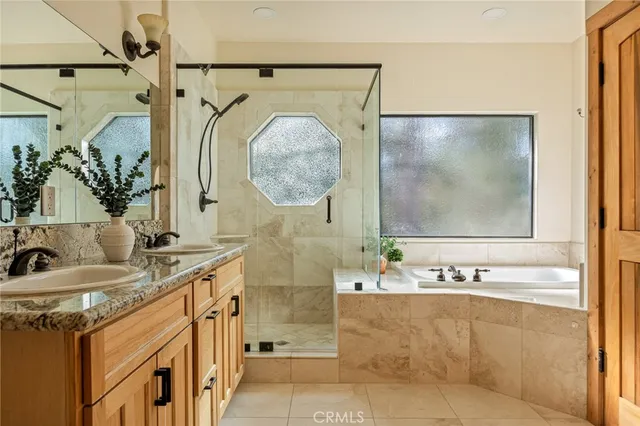 a bathroom with a granite countertop sink a mirror and shower