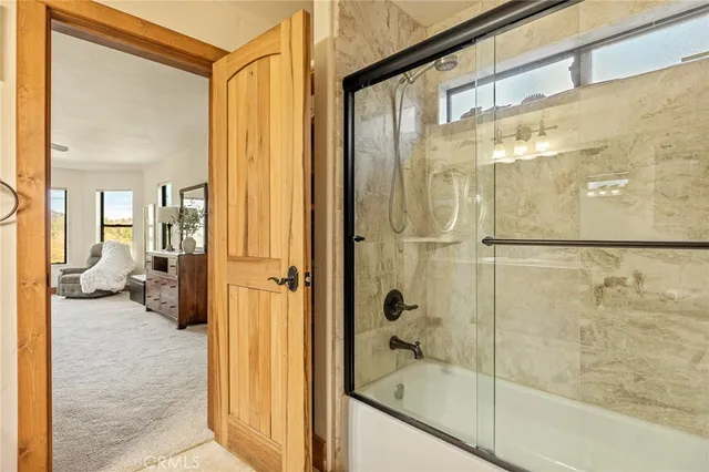 a living room with furniture a fireplace and large windows