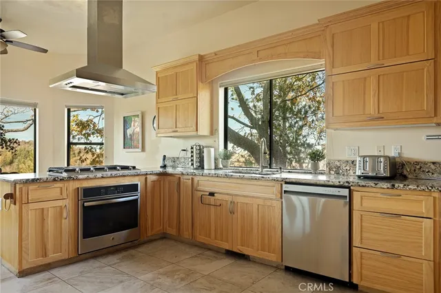 a kitchen with stainless steel appliances granite countertop white cabinets a sink and a stove