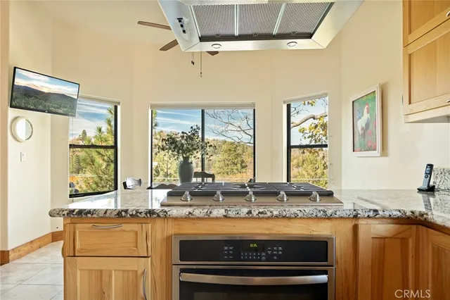 a bathroom with a granite countertop sink and a large mirror next to a window