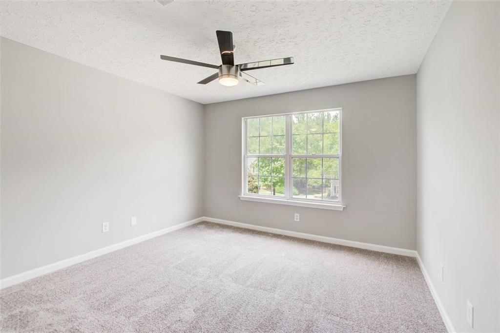 4110 Ridgebrook Bend Cumming, GA 30028 - Photo 41 of 49 an empty room with a ceiling fan and windows