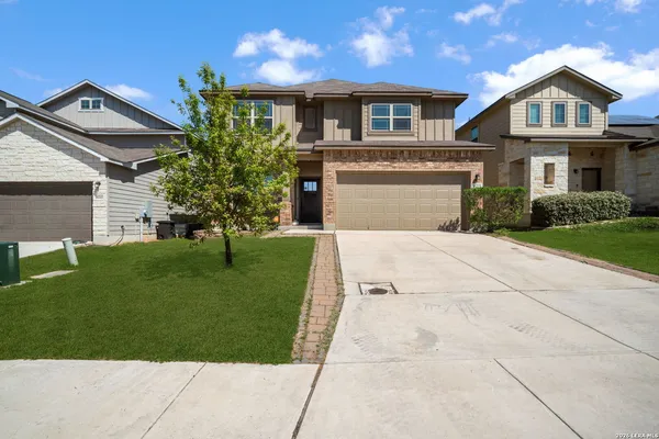 a front view of a house with a yard and trees