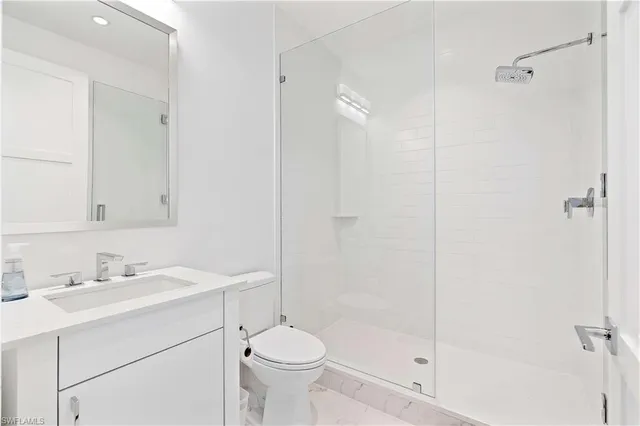 a bathroom with a sink toilet a mirror and shower