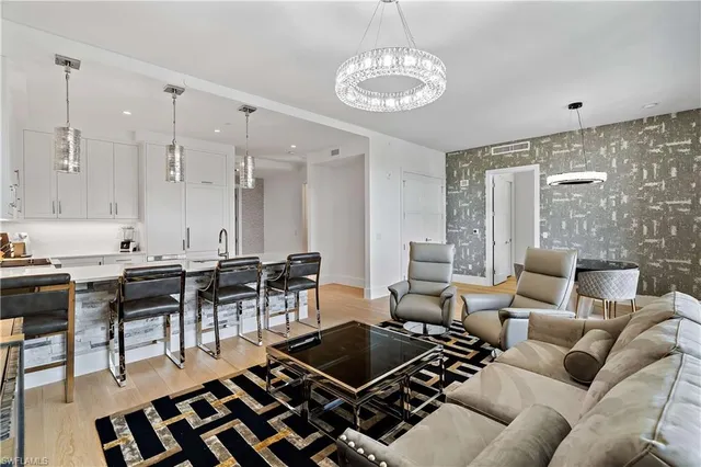 a living room with furniture a dining table and a chandelier