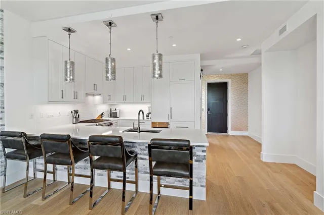 a kitchen with stainless steel appliances kitchen island granite countertop a table chairs and white cabinets