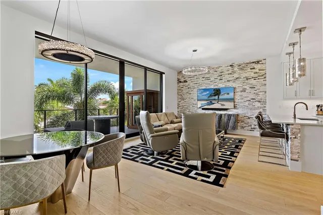 a dining room with furniture a chandelier and wooden floor