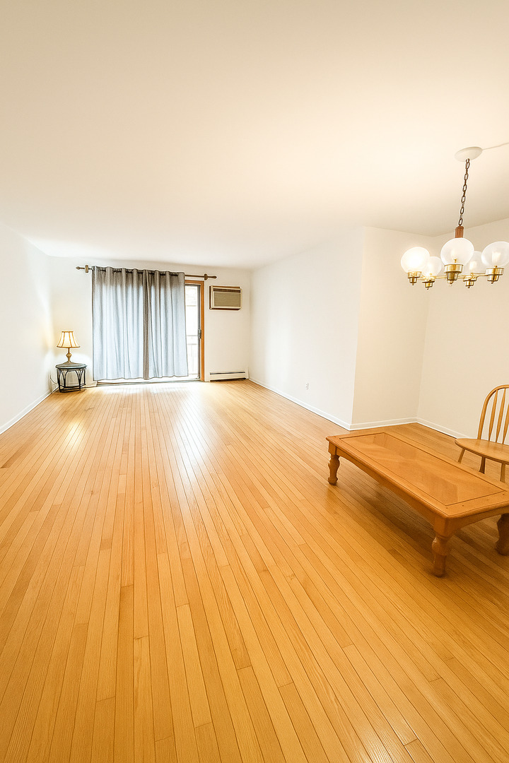 2139 North Harlem Avenue, Unit 224 Chicago, IL 60707 - Photo 5 of 18 a view of a bedroom with a large bed and wooden floor