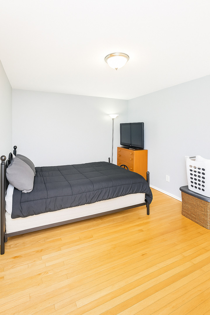 2139 North Harlem Avenue, Unit 224 Chicago, IL 60707 - Photo 10 of 18 a bedroom with a bed and a night stand