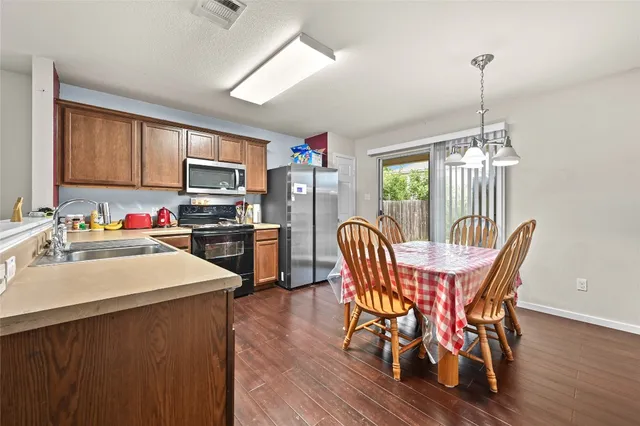 a dining room with furniture a chandelier and wooden floor