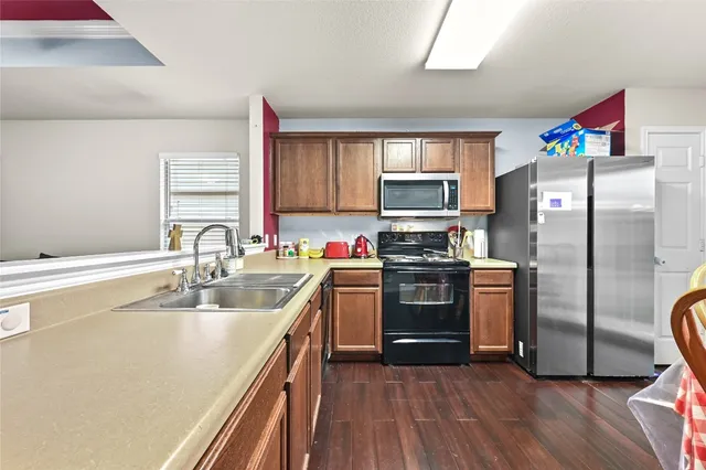 a kitchen with stainless steel appliances granite countertop a refrigerator sink and stove