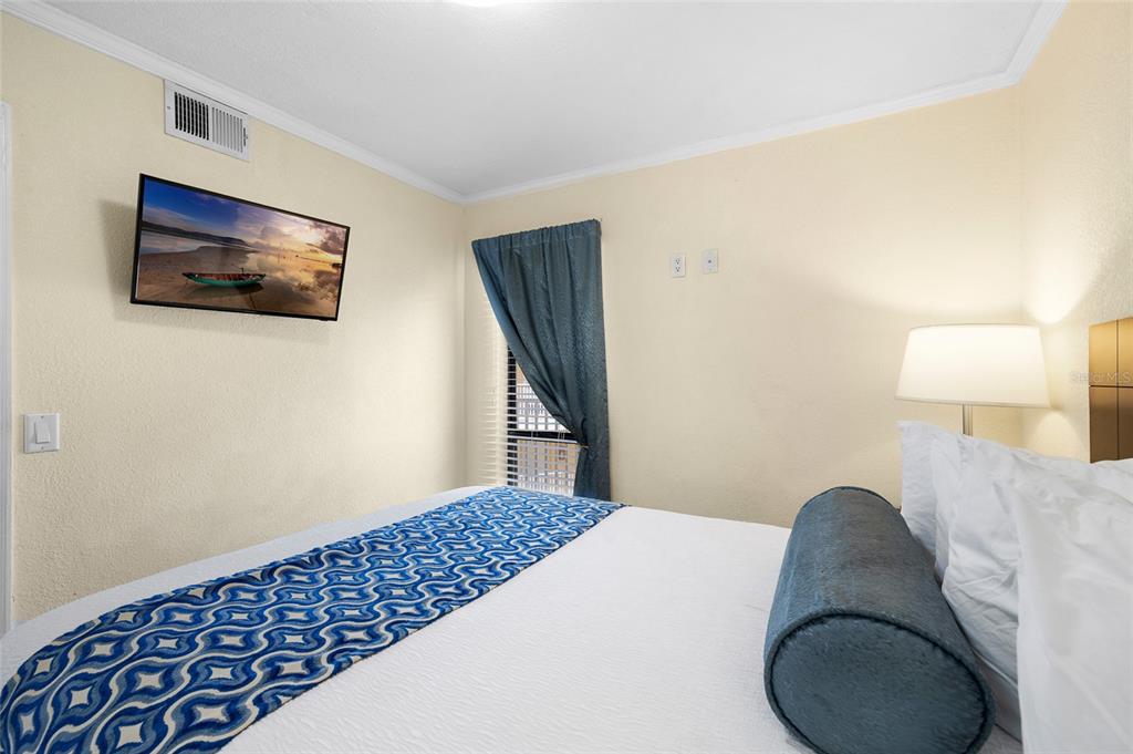 Undisclosed Address Tampa, FL 33607 - Photo 17 of 40 a bedroom with a bed and a lamp on the dresser