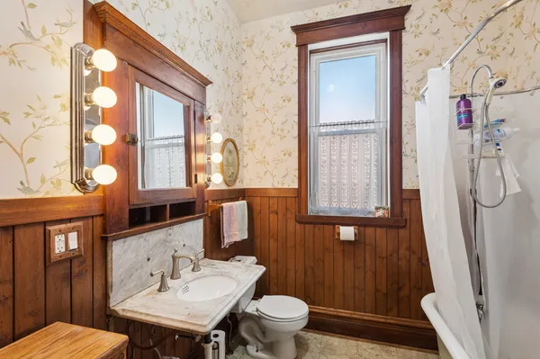 a bathroom with a sink a toilet and shower curtain
