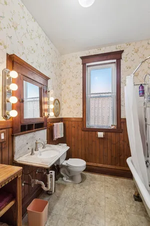 a bathroom with a sink toilet a mirror and shower