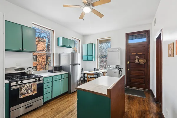 a kitchen that has a sink a stove and cabinets