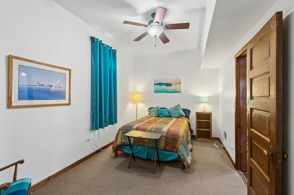 a bedroom with a bed and a refrigerator