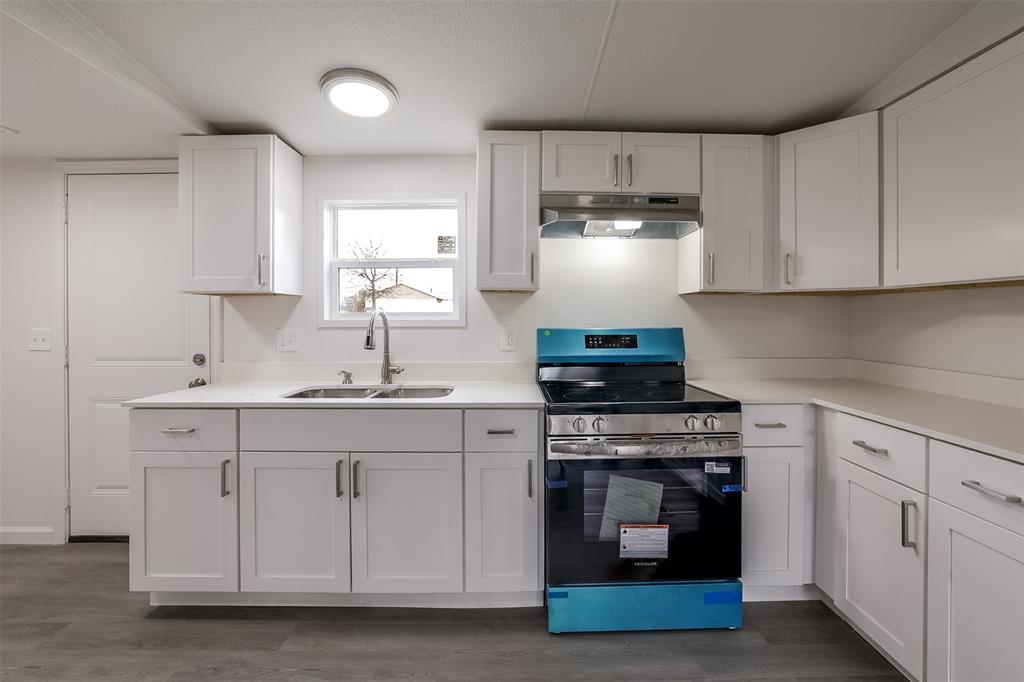 945 Walnut Street Azle, TX 76020 - Photo 11 of 29 a kitchen with white cabinets and appliances