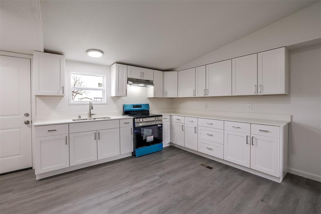 945 Walnut Street Azle, TX 76020 - Photo 13 of 29 a kitchen with sink a stove and cabinets