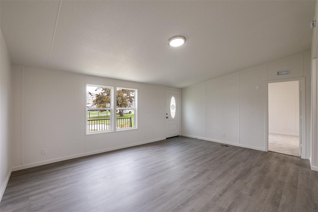945 Walnut Street Azle, TX 76020 - Photo 10 of 29 an empty room with wooden floor and windows