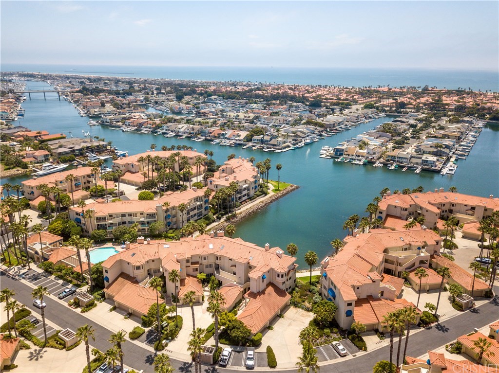 an aerial view of ocean and residential houses with outdoor space