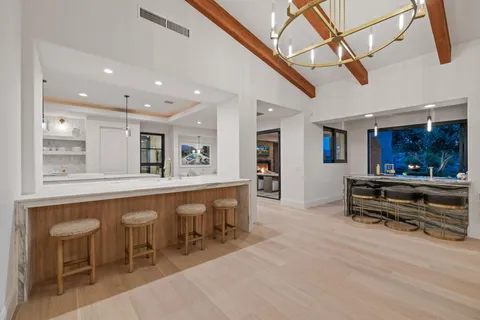 a kitchen with kitchen island stainless steel appliances sink and living room view