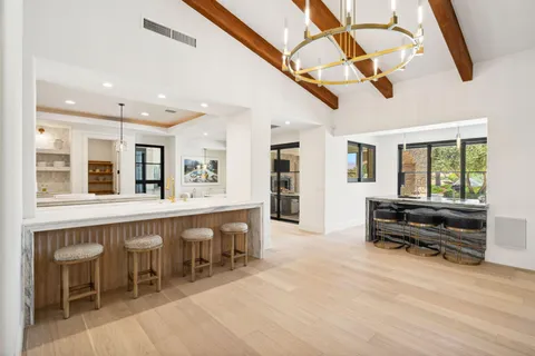 a kitchen with a sink and chairs