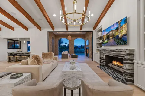 a living room with furniture a fireplace and a chandelier