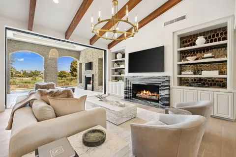 a living room with furniture a fireplace and a flat screen tv