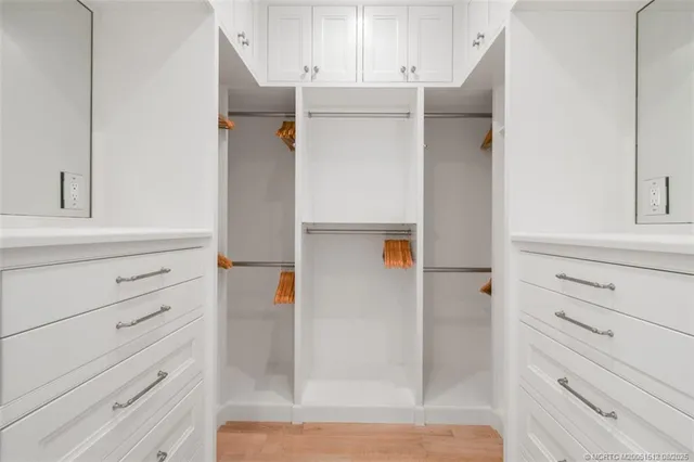 a spacious bedroom with a bed and a flat screen tv