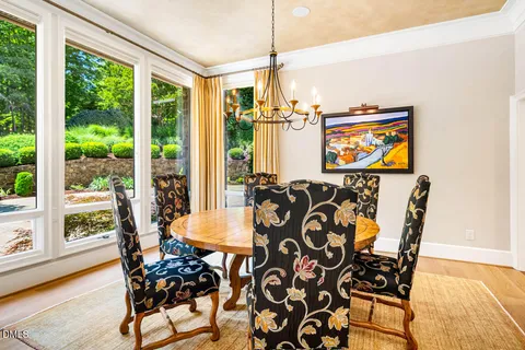 a open kitchen with stainless steel appliances granite countertop a stove a refrigerator a kitchen island a dining table and chairs with wooden floor