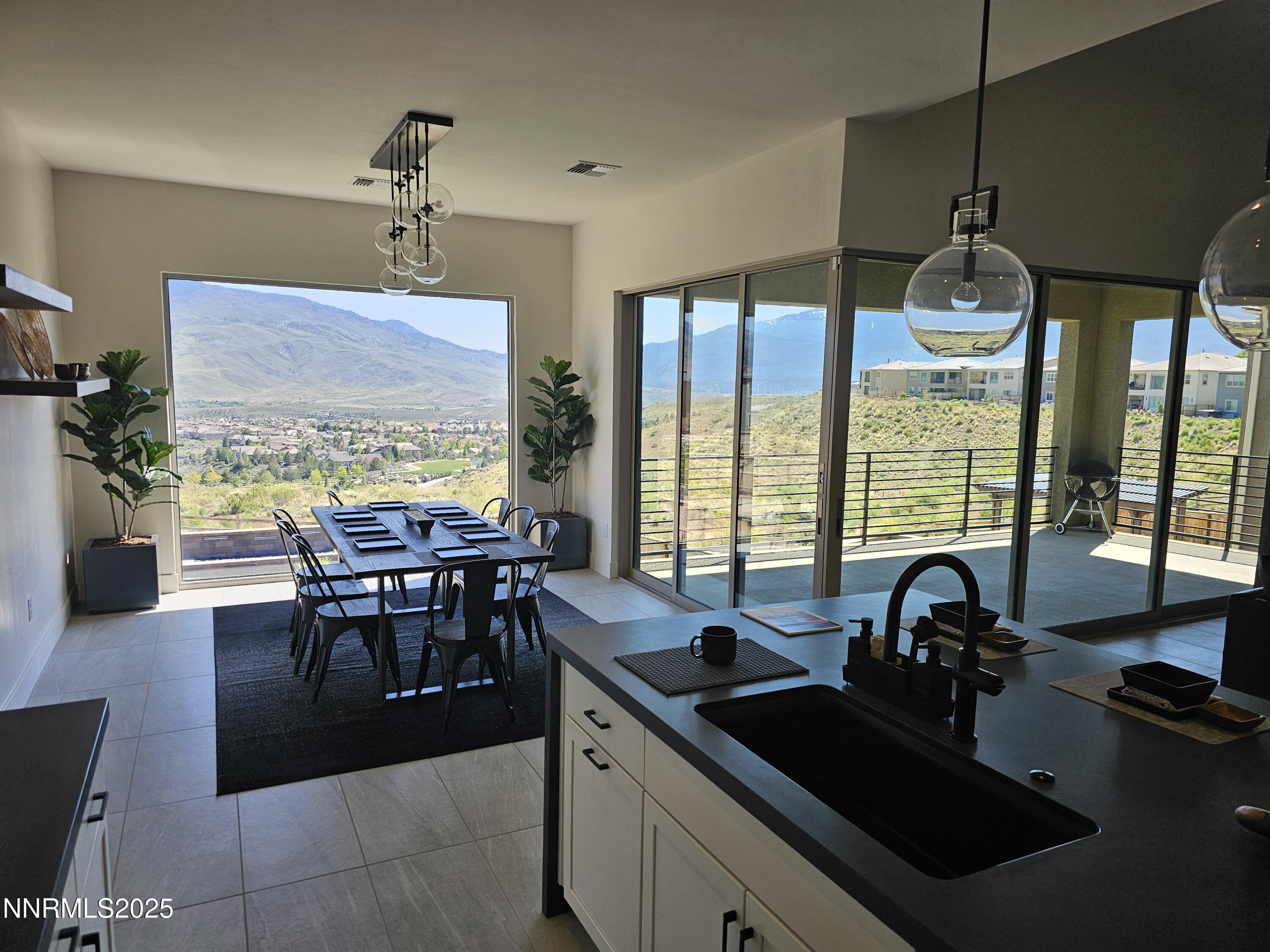 9110 Wild Skies Way Reno, NV 89523 - Photo 11 of 46 a kitchen with granite countertop a sink dining table and chairs