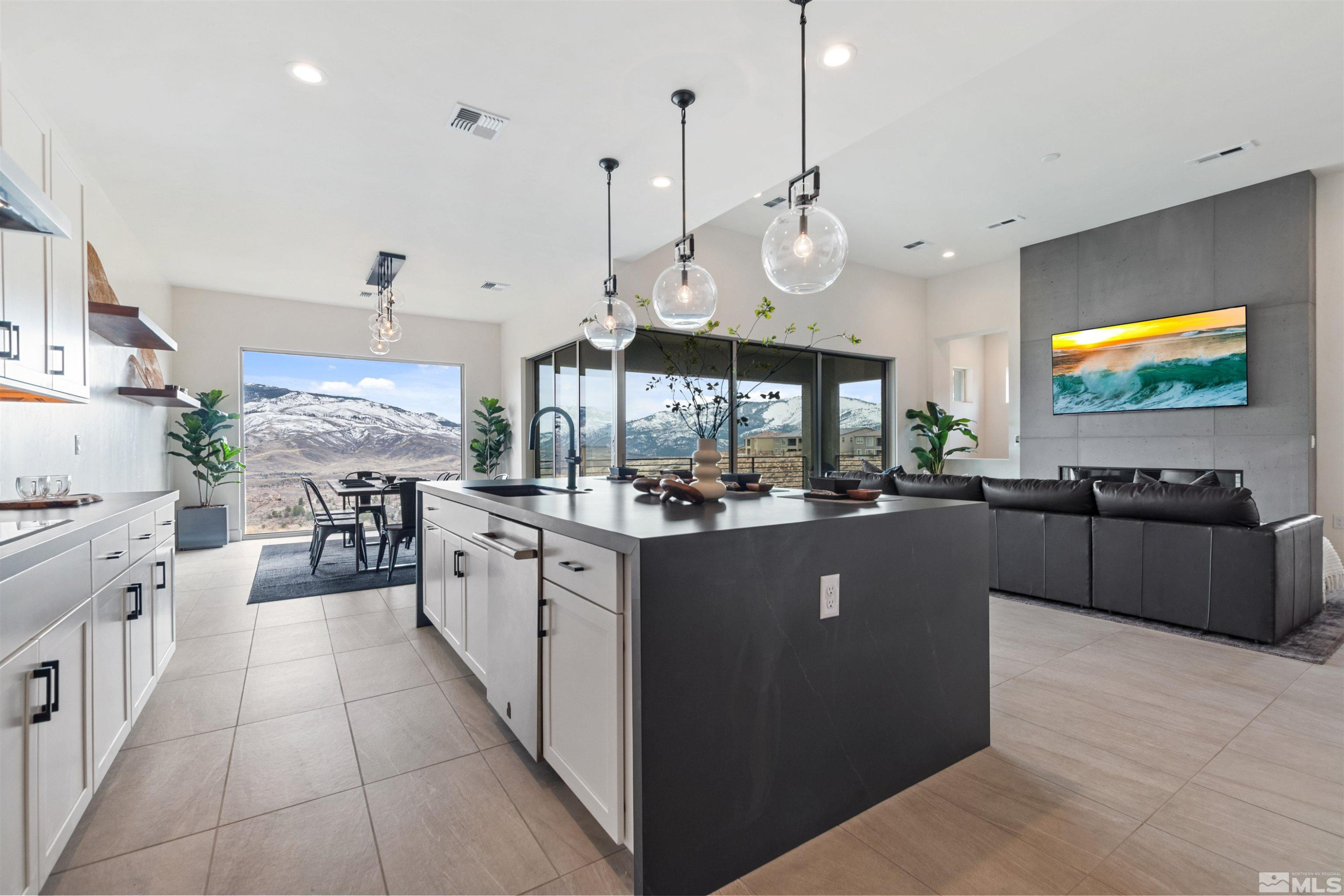 9110 Wild Skies Way Reno, NV 89523 - Photo 18 of 46 a large kitchen with stainless steel appliances granite countertop a stove a sink dishwasher a living room with couches and kitchen view