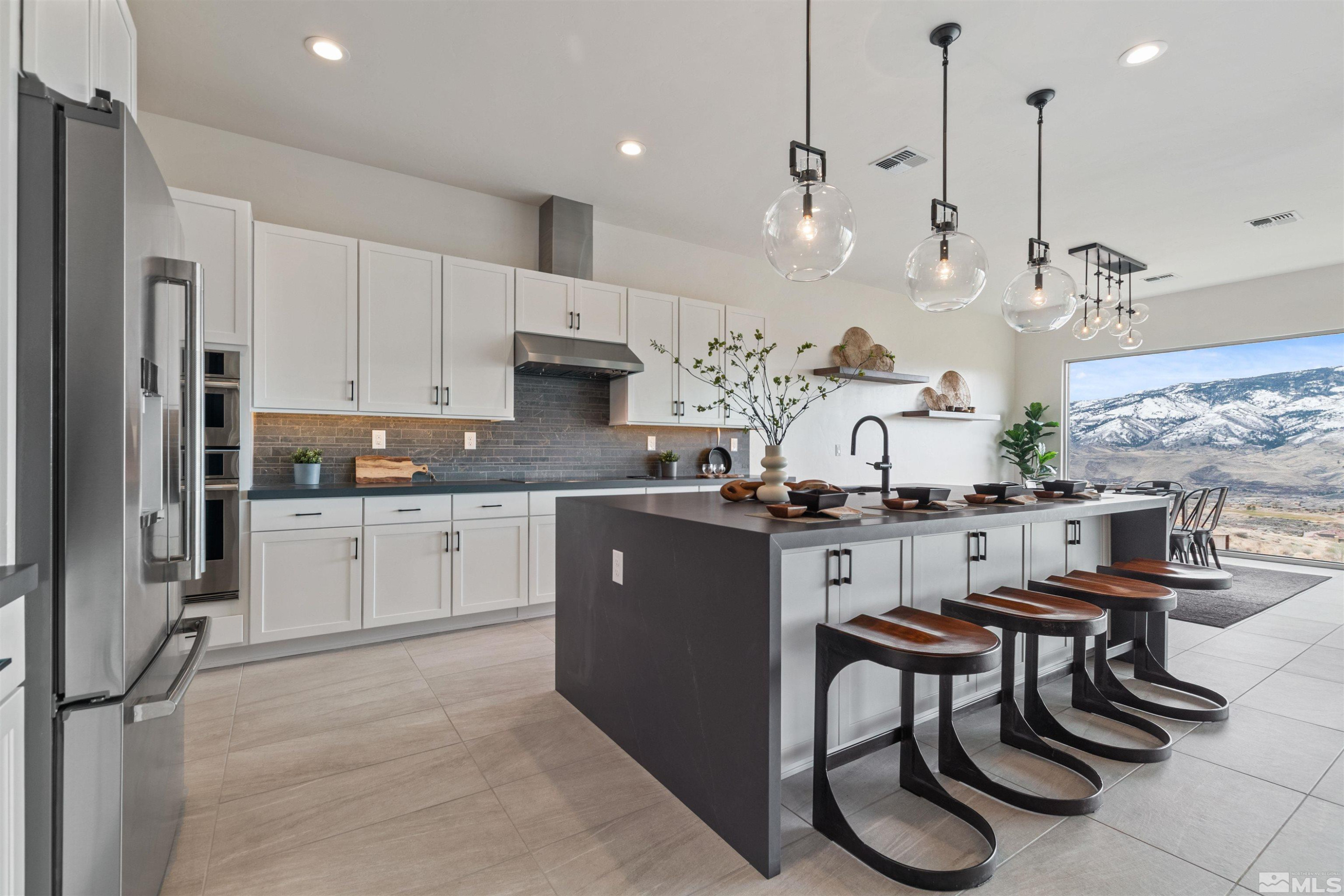 9110 Wild Skies Way Reno, NV 89523 - Photo 20 of 46 a kitchen with kitchen island granite countertop wooden cabinets and refrigerator