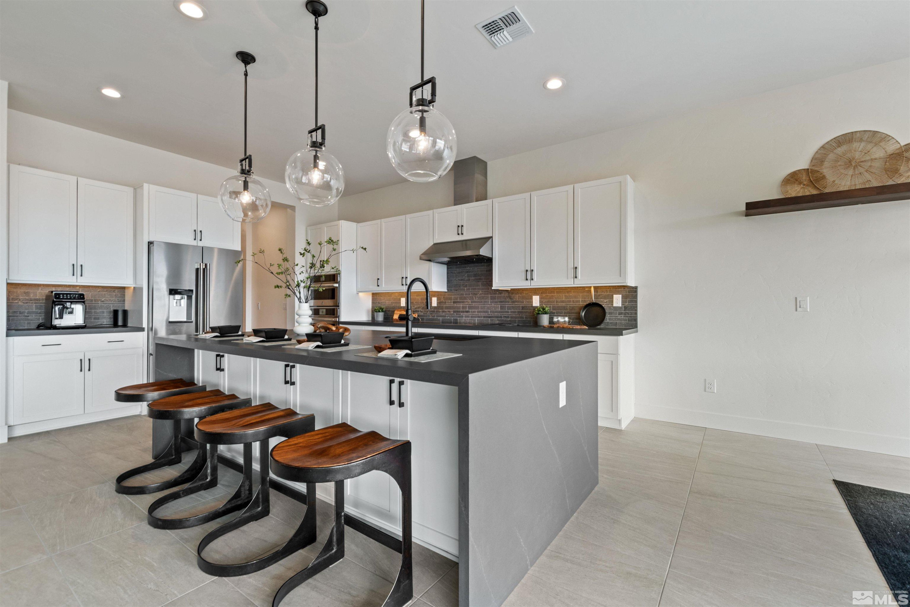 9110 Wild Skies Way Reno, NV 89523 - Photo 21 of 46 a kitchen with stainless steel appliances kitchen island granite countertop a sink a counter space and cabinets